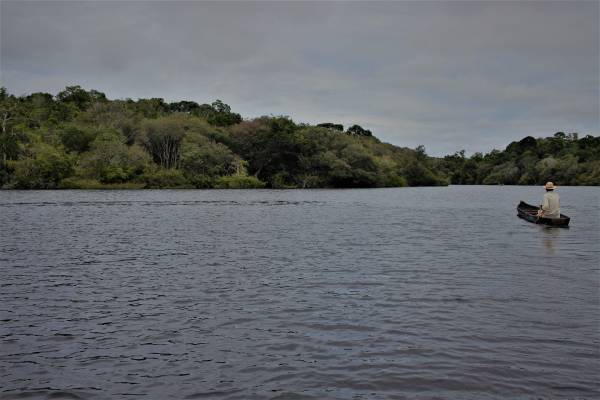Canoeiro navegando pelo rio negro.