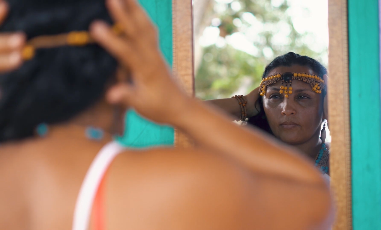 Mulher indígena se olhando no espelho.