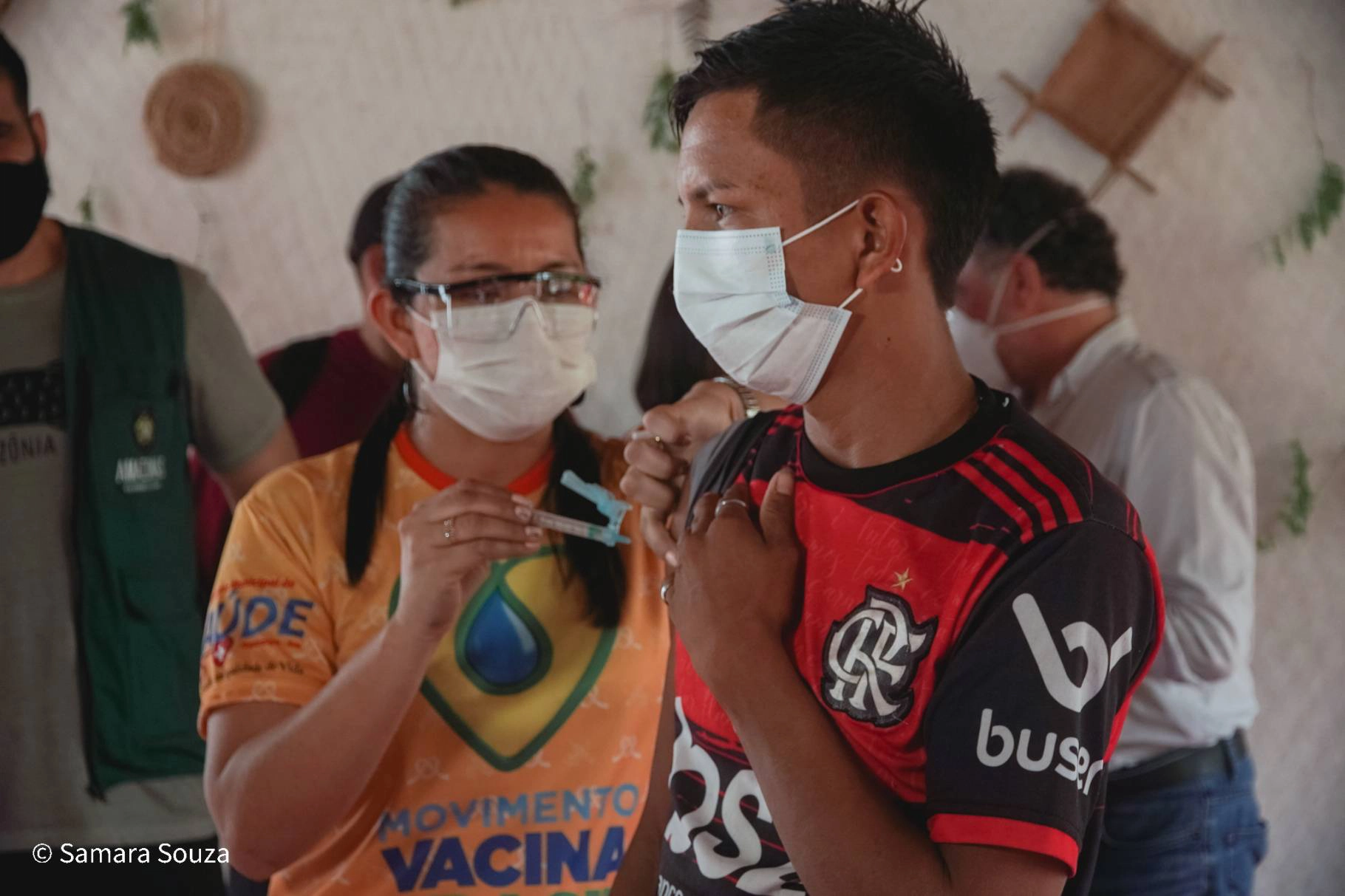 Mulher vacinando homem, através do Programa Saúde da Floresta, realizado pela Fundação Amazônia Sustentável (FAS).