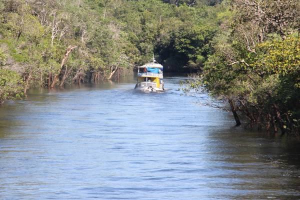 Barco navegando no meio do Rio Amazonas.
