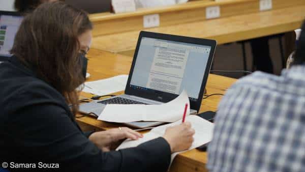 Mulher assinando documentos em uma bancada na Fundação Amazônia Sustentável.