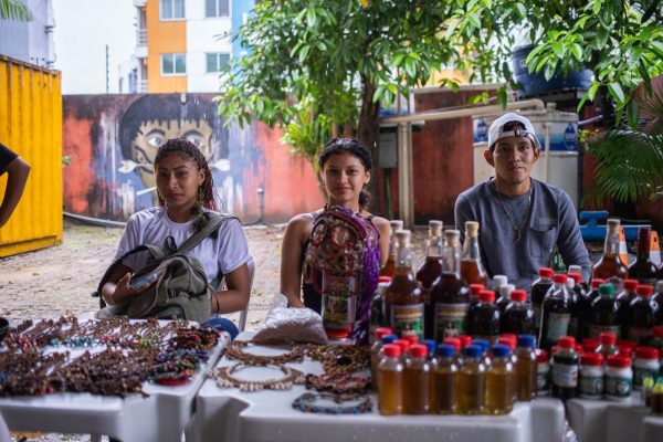 Três pessoas sentadas em cadeiras, participando da Feira da FAS, realizada pela Fundação Amazônia Sustentável (FAS).