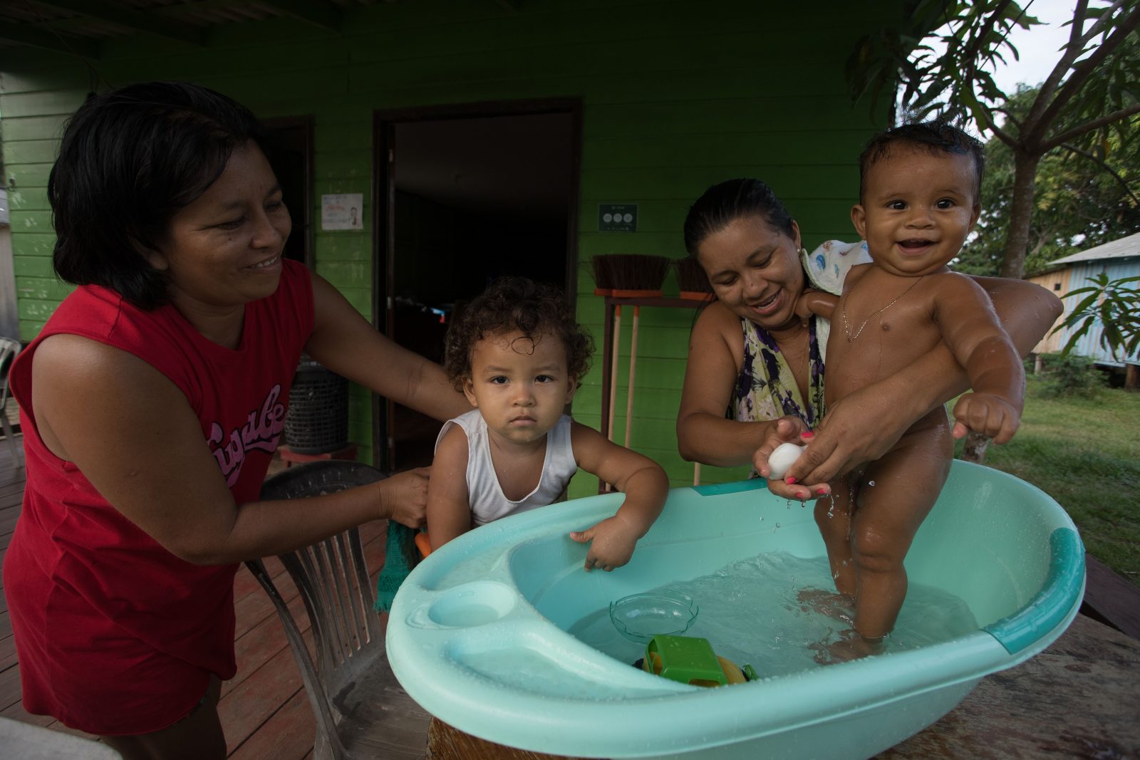 Mulheres dando banho em crianças no interior do Amazonas.