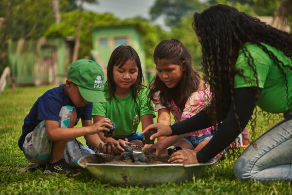 Colaboradora da Fundação Amazônia Sustentável (FAS), durante atividade ambiental com crianças em comunidade no interior do Amazonas.